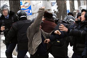 Kazakh riot police officers detain  demonstrators during an opposition rally in Kazakhstan's  commercial capital Almaty Saturday.