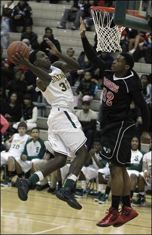 Start's Scott Hicks leaps for a basket while being guarded by Rogers' DeVonte Pratt. Hicks had 10 points in the loss.