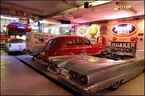 A 1998 Corvette convertible, on lift in background, is among Chuck Hymore's vintage car collection.