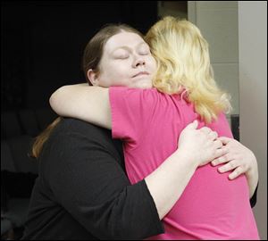 Mary Blair, left, hugs her mother Erma Oswalt, right, who has cancer, before getting food at Nightingale's Harvest, which is a food bank that helps cancer patients and their families.