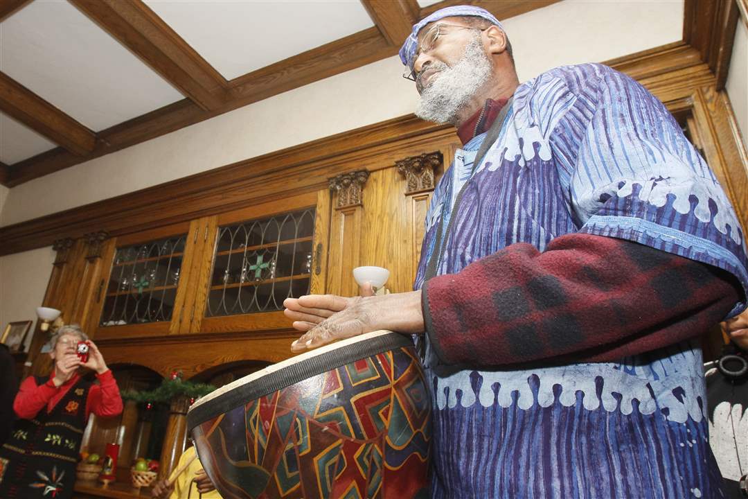 Poet-and-drummer-Kewape-plays-a-drum-to-open-the-Kwanzaa-program