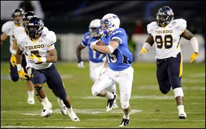 Air Force wide receiver Jonathan Warzeka, center, runs away from Toledo safety Diauntae Morrow, left, and Elijah Jones (98) during the first half of the Military Bowl.