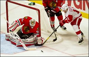 Detroit Red Wings Dan Cleary, right, has his shot blocked by the Chicago Blackhwks goalie Corey Crawford, left, in the third period as the Blackhawks defeated the Red Wings 3-2 in an NHL hockey game in Chicago on Friday.