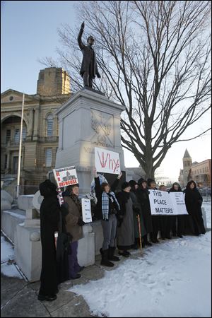 Protestors in front of the statue of William Harvey Gibson on the courthouse lawn. Protestors gather at the 1884 Seneca County courthouse as final preparations are made for its demolition in Tiffin, Ohio on Tuesday.