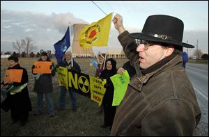Joseph Demare of Bowling Green shouts 'no more nukes,' as protesters perform near Davis-Besse.