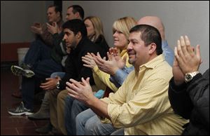Ray Campos, front, and other supporters applaud P.J. Kapfhammer as he is sworn into his new school board post. 