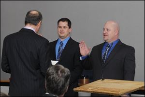 Oregon Mayor Mike Seferian swears in Jeff Ziviski and P.J. Kapfhammer to the Oregon School Board. The two new board members won their seats after they campaigned against approved raises for Superintendent Michael Zalar and other administrators.