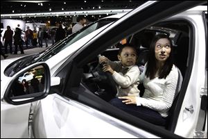 Katherine McCarter, with her son, Gabriel, 3, get the feel of a Buick Regal on display at the auto show.