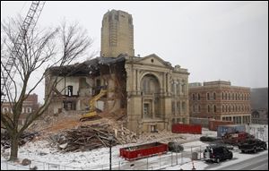 A widening hole of the Seneca County Courthouse is exposed as wrecking crews tear away more of the 1884 Tiffin landmark.
