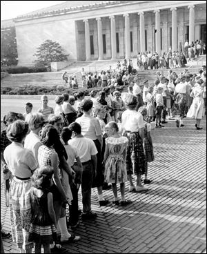 Children line up outside of the Toledo Museum of Art with their parents on registration day for Saturday classes in 1955. 
