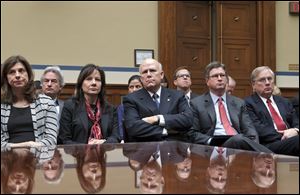 General Motors CEO Dan Akerson, center, flanked by GM staff , listens to opening statements by the House Regulatory Affairs, Stimulus Oversight and Government Spending subcommittee, on Capitol Hill in Washington, as it held a hearing on the safety of the all-electric car, the Chevy Volt. 