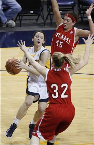 Toledo’s Courtney Ingersoll drives between Miami’s Kirsten Olowinski (45) and Hannah Robertson (32). Ingersoll scored eight points as the Rockets defeated the RedHawks to stay atop the West Division.