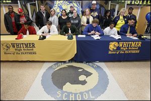 With their parents behind them, Whitmer seniors sign national letters of intent to play college football — from left, Leroy Alexander (Nebraska), Nick Logenbarger (Findlay), Mark Meyers (Michigan State), Storm Norton (Toledo), Jody Webb (Toledo) and Chris Wormley (Michigan). The Panthers finished 13-1, were ranked No. 2 in Ohio in Division I, and reached the state semifinals for the second straight year.