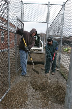 Workers replace the grass in the dog runs outside the dog warden's South Erie Street facility with gravel. The new gravel areas allow for easier cleanup. The Lucas County Dog Warden Advisory Committee met Thursday to discuss recent improvements at the facility.