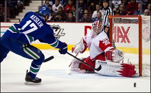 Detroit Red Wings goalie Jimmy Howard, right, stops a shot by Vancouver Canucks' Ryan Kesler during the first period.