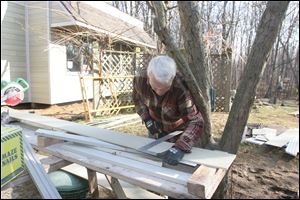 Larry Fisher of Comte Construction Co. forgoes a hat as he works on renovating the Yager Center at Swan Creek Metropark. 