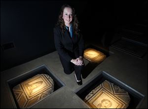 Dr. Stephanie Langin-Hooper, Assistant Professor of Ancient Art History,  kneels near ancient mosaics at the Wolfe Center at Bowling Green State University, Tuesday.