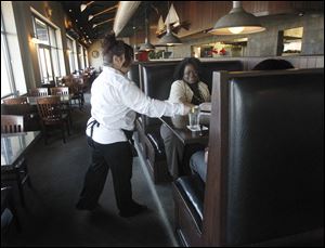 Lisa Schnabel, left, serves customer Robin Reid at Admiral’s American Grill. El Vaquero’s electric bill is currently billed to Admiral’s. 