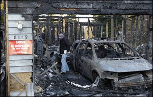 An investigator walks through the garage area in the rubble of the home in Graham, Wash., where Josh Powell and his two sons were killed Sunday in what police said appeared to be a deliberately set fire. 