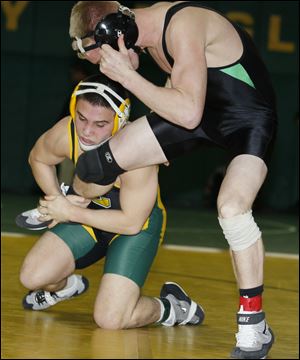 Clay senior Angelo Amenta grabs the leg of Delta's Luke Kern at the Maumee Bay Classic. Amenta, 32-8 this season, placed third at state last year.
