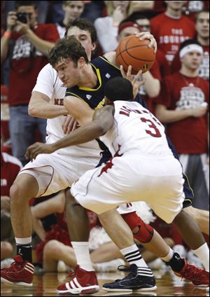 Michigan's Zack Novak, center, drives through Nebraska's Mike Fox, rear, and Brandon Richardson (3) in the first half Wednesday night's game.