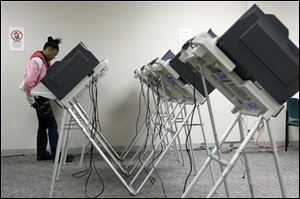 Alexis Lanier, of Toledo, studies the ballot as she votes Jan. 31 at the Lucas County Early Vote Center on Washington Street.