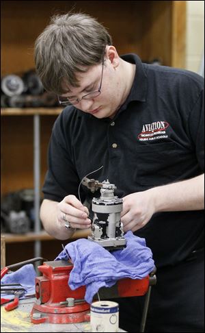 Leonard Kaczmark II, 18, works on the safety wiring for a propeller governor at the Aviation Center at Toledo Express Airport.