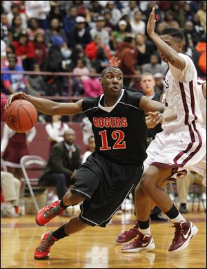 Rogers High School player Clemmye Owens, 12, drives inside against Scott High School player Rashad Lane, 14.