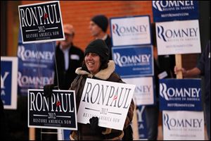 Merav Yaakov of Manchester, N.H., hold signs in support of Republican presidential candidate Ron Paul outside a January event for candidate Mitt Romney at the Pinkerton Academy in Derry, N.H. 