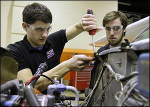 Michael Flory, 18, left, and Steven Daniels, 20, replace a fastener on a Cessna airplane. Both are seniors in the TPS aviation program.