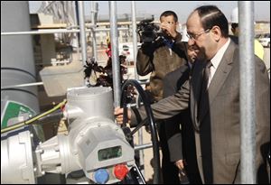 Iraq's Prime Minister Nouri al-Maliki, right, symbolically opens the valve of a new oil export terminal in the Persian Gulf, southern Iraq, Sunday.