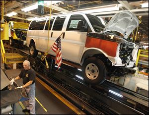A General Motors employee works on a van assembly line at GM's plant in Wentzville, Mo.