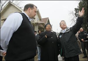 Lucas County Treasurer Wade Kapszukiewicz, left, Toledo Councilman Paula Hicks-Hudson, center, and Ohio Attorney General Mike DeWine tour properties on Mentor Drive in North Toledo.