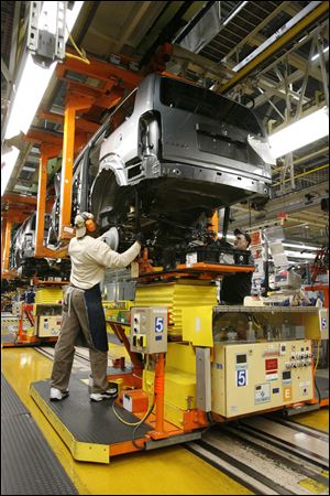 Workers attach the rear axle with the help of a machine at Chrysler's Toledo North Assembly. Employers will seek more workers with higher skills than just having a strong back, and that includes working with computers.
