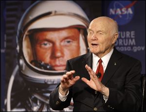 Sen. John Glenn talks, via satellite, with the astronauts on the International Space Station, before the start of a roundtable discussion titled 