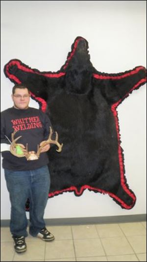 Cory Manders, a junior at Whitmer, shows off his rug from the hide of a 250-pound bear he took.