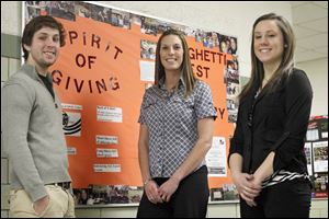 Tricia Sharp, Spirit of Giving president, is flanked by student members Hunter Lonseth, left, and Tori Jennings in front of a bulletin board promoting the Spaghetti Fest.