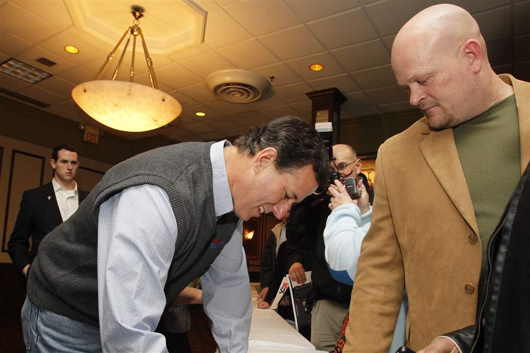 Republican-presidential-candidate-Rick-Santorum-signs-a-pamphle