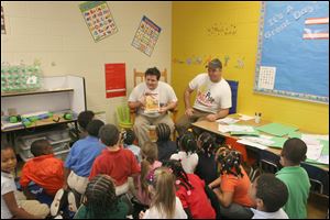 Nick Rokicki, from left, and Joe Kelley read their book 'Pete the Popcorn' to first graders at Leverette Elementary School. 'Pete the Popcorn
