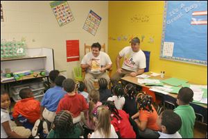 Nick Rokicki, from left, and Joe Kelley read their book 'Pete the Popcorn' to first graders at Leverette Elementary School. 'Pete the Popcorn