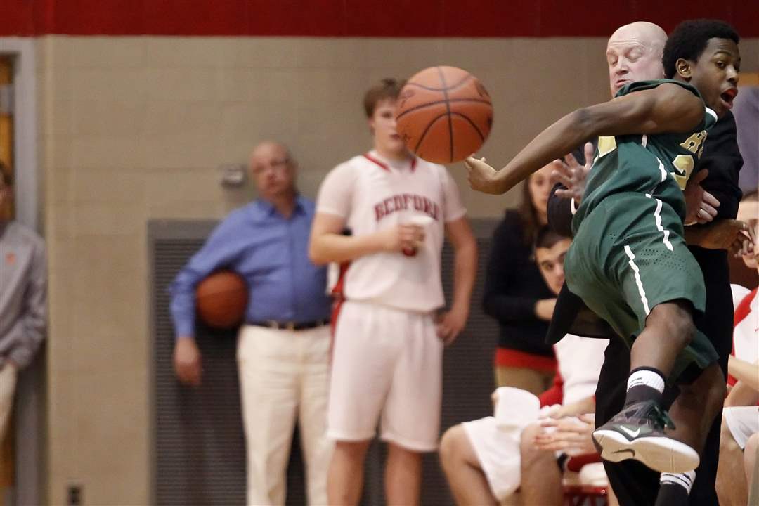 Ann-Arbor-Huron-s-Demetrius-Sims-20-collides-with-Bedford-head-coach-Nick-Lowe