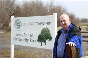 Commission Chairman John Mohr, standing by a new sign, says Ansted Park will be a 'natural park.' It has a half-mile walking trail. More are planned. So are a disc golf course, rest rooms, picnic areas, and an outdoor ice rink.
