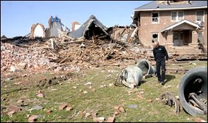 Insurance agent Jim Williams looks over the church bells that had fallen to the ground at St. Joseph's Catholic Church after a severe storm hit in the early morning hours in Ridgway, Ill.