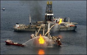 A rig burns oil and gas near the Discoverer Enterprise, background, at the site of the Deepwater Horizon oil spill in the Gulf of Mexico off the coast of Louisiana Saturday, June 19, 2010.