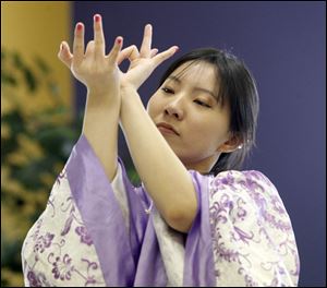 Leana Wu incorporates some complicated hand gestures during her portrayal of one of the dances demonstrated for visitors at the open house. Besides dancing, the open house featured demonstrations of self-defense incorporating Chinese kung-fu (with fist), tai chi fan, sword, broad sword, stick, duster/whip, and karate.