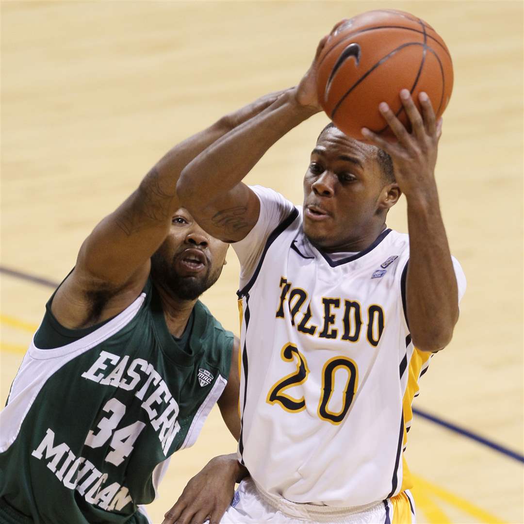 Toledo-s-Julius-Brown-20-looks-to-pass-while-being-guarded-by-Eastern-Michigan-s-Darrell-Lampley