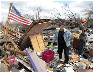 Melody Zollman finds a toy bear as she looks through the rubble of her home destroyed by a tornado in Henryville, Ind., in a scene repeated throughout the day.