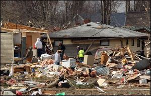 Residents search through the debris from Friday's storm in hopes of salvaging items on Sunday in Holton, Ind. A string of violent storms scratched away small towns in Indiana and cut off rural communities in Kentucky as an early-season tornado outbreak struck on Friday.