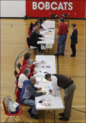 Nabieh Mikhail, left, assists voter Brady Gaskins at Bowling Green Senior High School. Among the questions on the ballot was a bond issue to build an outdoor pool.