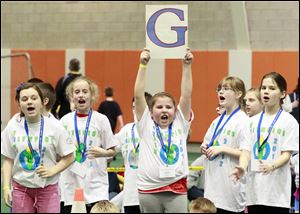 Paige Freeworth, 9, of Conneaut Elementary, holds up a G, which is her team's letter, to cheers.